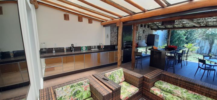 Área gourmet rústica com armários em vidro