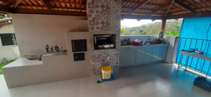Área gourmet com churrasqueira e armários em vidro